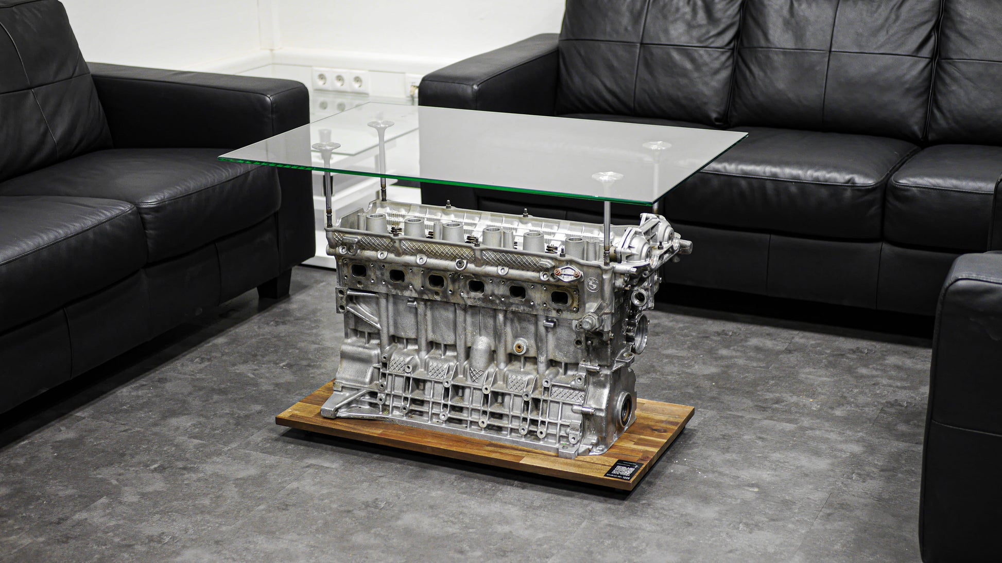 Motorblock-Tisch von BMW in der Farbe Silber. Tisch aus Autoteilen in der Seitenansicht.