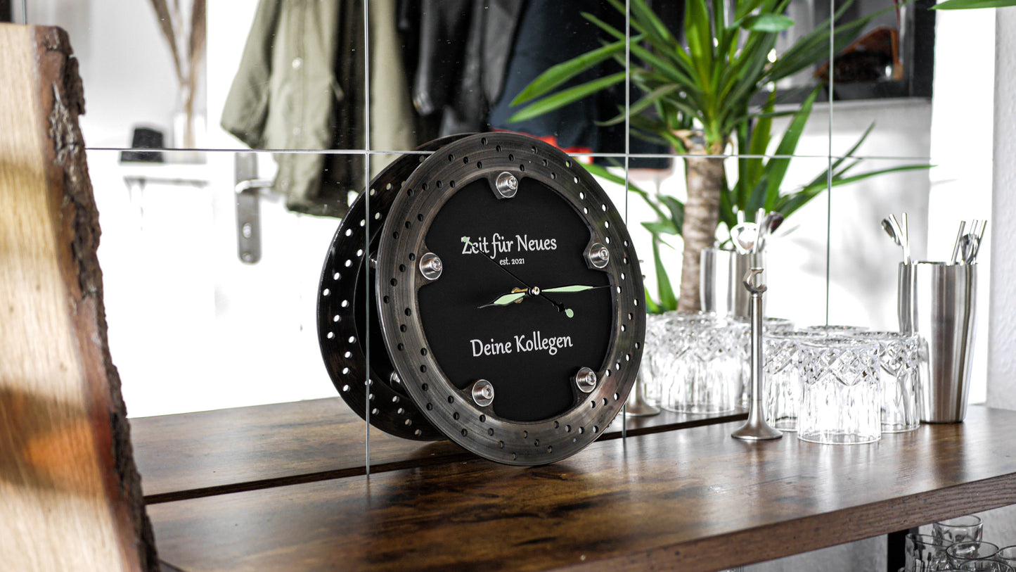 Wanduhr aus Motorrad-Bremsscheibe. Hochwertige Handarbeit, gefertigt aus recycelten Fahrzeugteilen für einen authentischen Industrie-Look.