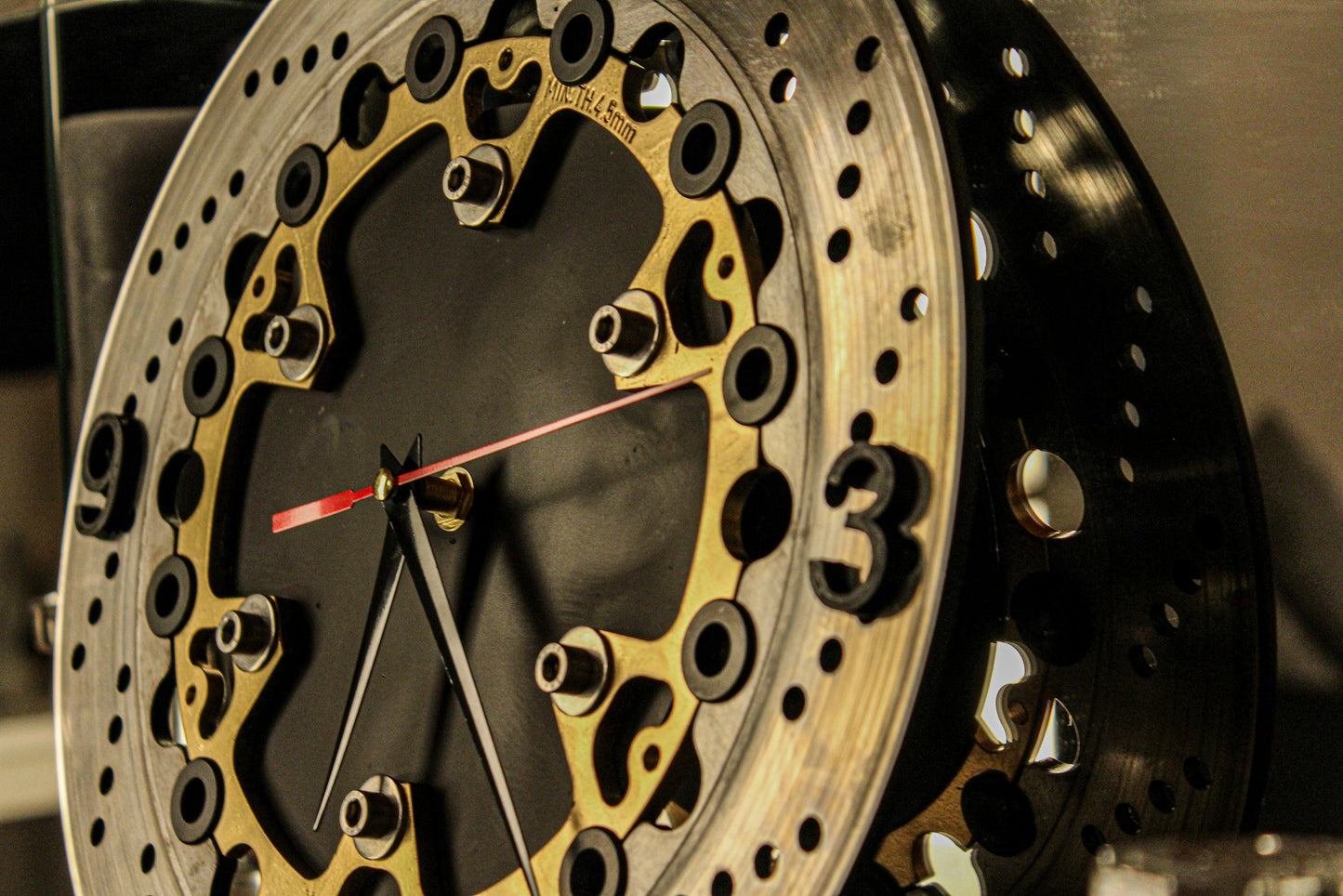 Detailaufnahme der stilvollen Bremsscheiben Uhr mit Ziffern und schwarzem Zifferblatt – Perfekt für moderne Wohnräume