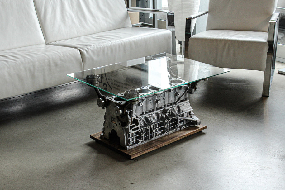Handgefertigter Motorblock Tisch mit Glasplatte in einem stilvollen Showroom – Industrial Design für Auto- und Motorsportfans